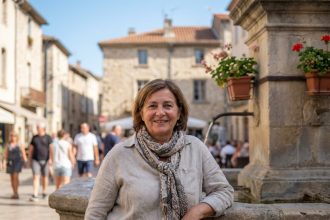 Femme méditerranéenne souriante devant une fontaine à Béziers